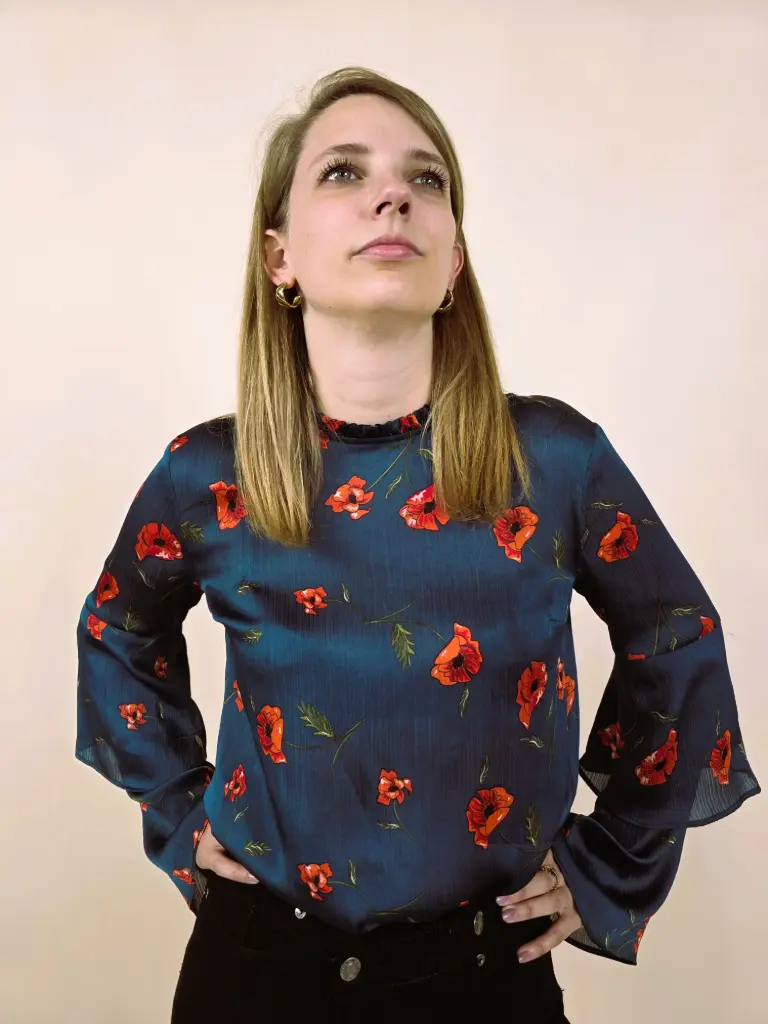 Blouse fluide bleu à imprimé floral rouge et manches cloche.